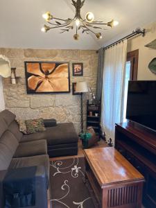 a living room with a couch and a flat screen tv at Casa Celsa cerca del mar in Baiona