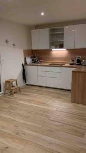 una cucina con armadietti bianchi e pavimenti in legno di Cœur de ville Loverien a Louviers