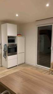 una cucina con frigorifero bianco e piano cottura di Cœur de ville Loverien a Louviers
