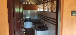eine Küche mit einem Herd und einem Waschbecken in einem Zimmer in der Unterkunft Cleveland Resorts Kanthalloor in Kanthalloor