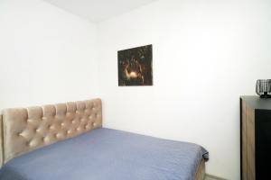 uma cama num quarto com uma fotografia na parede em Central Station Apartment No7 em Kaunas