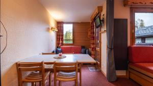 a small dining room with a table and chairs at les arcades a37 4 pers in Doucy