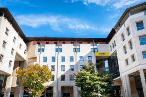 a large white building with trees in front of it at Staycity Aparthotels Marseille Centre Vieux Port in Marseille