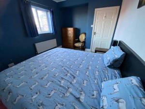 a blue bedroom with a bed with birds on it at Wellbet Farm in Swinderby