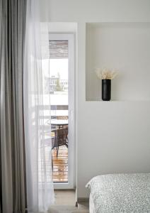 a bedroom with a door to a balcony with a table at Central Station Apartment No7 in Kaunas