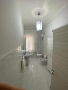 uma casa de banho branca com um lavatório e um WC em Alloggio Salice em Acerra