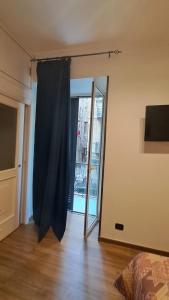een kamer met een glazen schuifdeur en een raam bij La Casetta di Napoli di Silvano in Napels