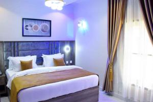 a bedroom with a large bed and a window at Castle Estate APartments in Abuja