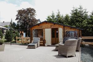 Un pequeño cobertizo de madera con sillas y un patio. en Glamping Hütte Hygge, en Winterberg