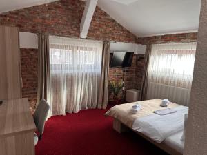 a hotel room with a bed and a television at Pensiunea SADA in Făgăraş