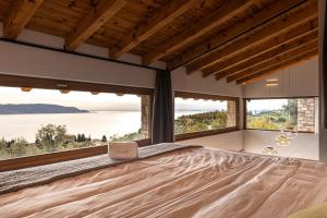 a bedroom with a large bed with a laptop on it at Colago Private Villas Lake Garda in Toscolano Maderno