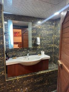 y baño con lavabo y espejo. en Muzepotamia Butik Otel en Sanlıurfa