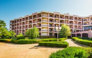 un edificio de apartamentos con árboles delante de él en Pyramisa Island Hotel Aswan, en Asuán