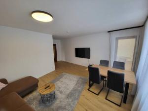 un soggiorno con divano, tavolo e sedie di Schönes Ruhiges Appartement a Crailsheim