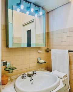 W łazience znajduje się umywalka i lustro. w obiekcie paolohome w Mediolanie