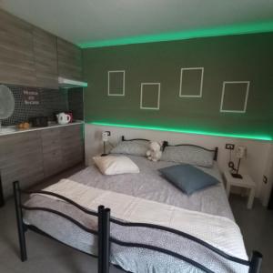 a bedroom with a large bed with green lighting at villa verde bed and breakfast in Uggiate