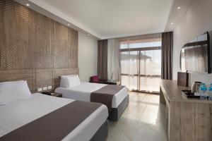 a hotel room with two beds and a television at Pyramisa Island Hotel Aswan in Aswan