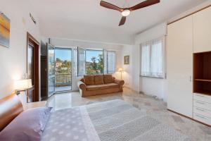 a bedroom with a bed and a couch and windows at Tramontana in Celle Ligure
