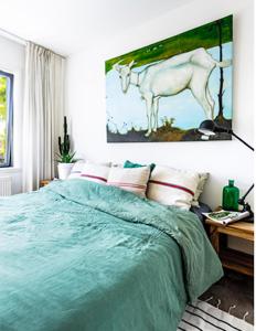 a bedroom with a bed with a painting of a horse at Apartment close to campus in Nijmegen