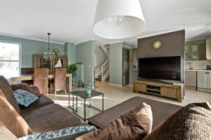 a living room with a couch and a flat screen tv at Hele Huset - Nært Oslo Lufthavn in Nannestad