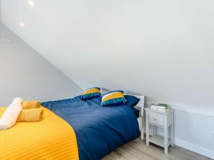 um quarto com uma cama com lençóis azuis e amarelos em 1 Bed in Lymington 81429 em Lymington