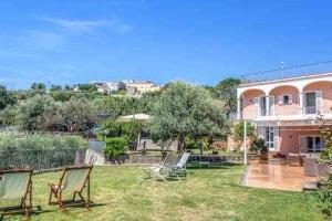two lawn chairs sitting in the yard of a house at Campanella Villas Gardens Pool Superview in Termini