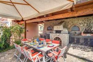 a patio with a table and chairs and a stone oven at Campanella Villas Gardens Pool Superview in Termini