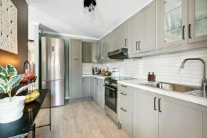 a kitchen with white cabinets and stainless steel appliances at Hele Huset - Nært Oslo Lufthavn in Nannestad