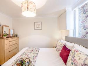 een slaapkamer met een bed, een dressoir en een raam bij 1 bed in Holywell 82277 in Whitford