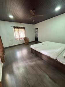1 dormitorio con 1 cama grande y suelo de madera en The Wild Fo'rest Resorts en Masinagudi
