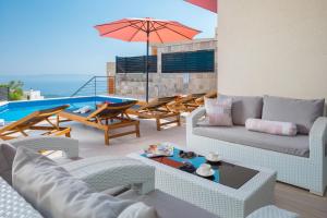 a living room with couches and a swimming pool at Villa Harmony in Makarska