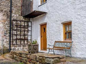 eine Bank, die vor einem Gebäude mit einer Tür sitzt in der Unterkunft 2 bed in Nantyglo 82706 in Nantyglo