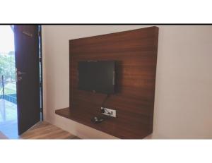 TV de pantalla plana en la pared de una habitación en Shangrila's Hotel Sai Chandra, en Shirdi