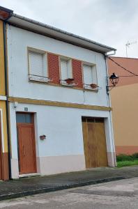 ein weißes Gebäude mit zwei Türen und zwei Fenstern in der Unterkunft Casa MaySa in Cacabelos