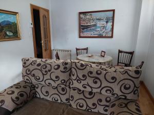 a living room with a couch and a table at Casa MaySa in Cacabelos