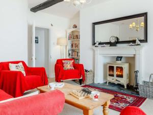 a living room with red chairs and a fireplace at 3 Bed in Llangorse BN331 in Cathedine