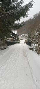 uma estrada coberta de neve com uma casa à distância em Ojców, Na Widoku em Ojców