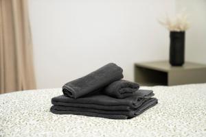 a pile of towels sitting on top of a bed at Central Station Apartment No8 in Kaunas