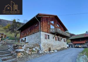 a large wooden building with a balcony on a road at Luxueux chalet 5 chambres in Brizon