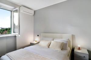 ein weißes Schlafzimmer mit einem Bett und einem Fenster in der Unterkunft via Giardino Grande in Cervo