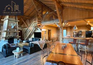 a living room with a couch and a table at Luxueux chalet 5 chambres in Brizon
