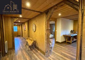 a room with a wooden wall with a table in it at Luxueux chalet 5 chambres in Brizon