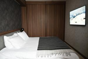 a bedroom with a bed with a tv on the wall at KOPAONIK WOODSIDE 58,70 m2 FREE Parking in Kopaonik