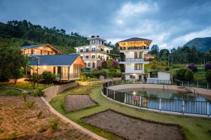 a house with a pool in front of a building at Cleveland Resorts Kanthalloor in Kanthalloor