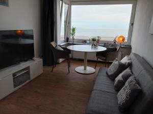 - un salon avec un canapé et une table dans l'établissement App Seaview Albert I, à Ostende