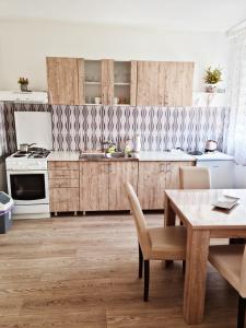 a kitchen with wooden cabinets and a table with chairs at CityS in Apatin