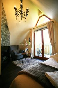 1 dormitorio con cama y lámpara de araña en Apartament Glamour I, en Zakopane