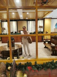 une femme debout devant un miroir dans l'établissement Unit 402, Cedar Peak, à Baguio