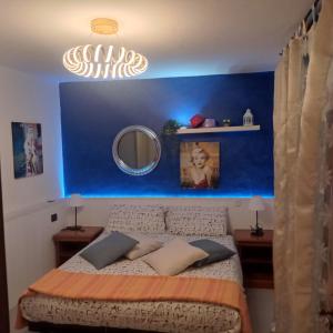 um quarto azul com uma cama e um espelho em villa verde bed and breakfast em Uggiate