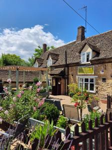 an old stone house with a garden in front of it at The horse and panniers guest house. in North Luffenham